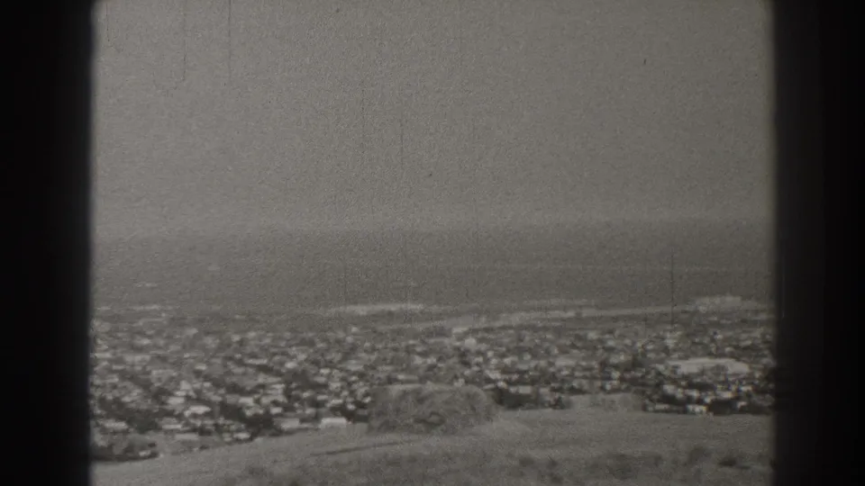 A grainy 1937 Long Beach coastal panorama shows buildings below the ocean horizon, bisected by a dark foreground bar.