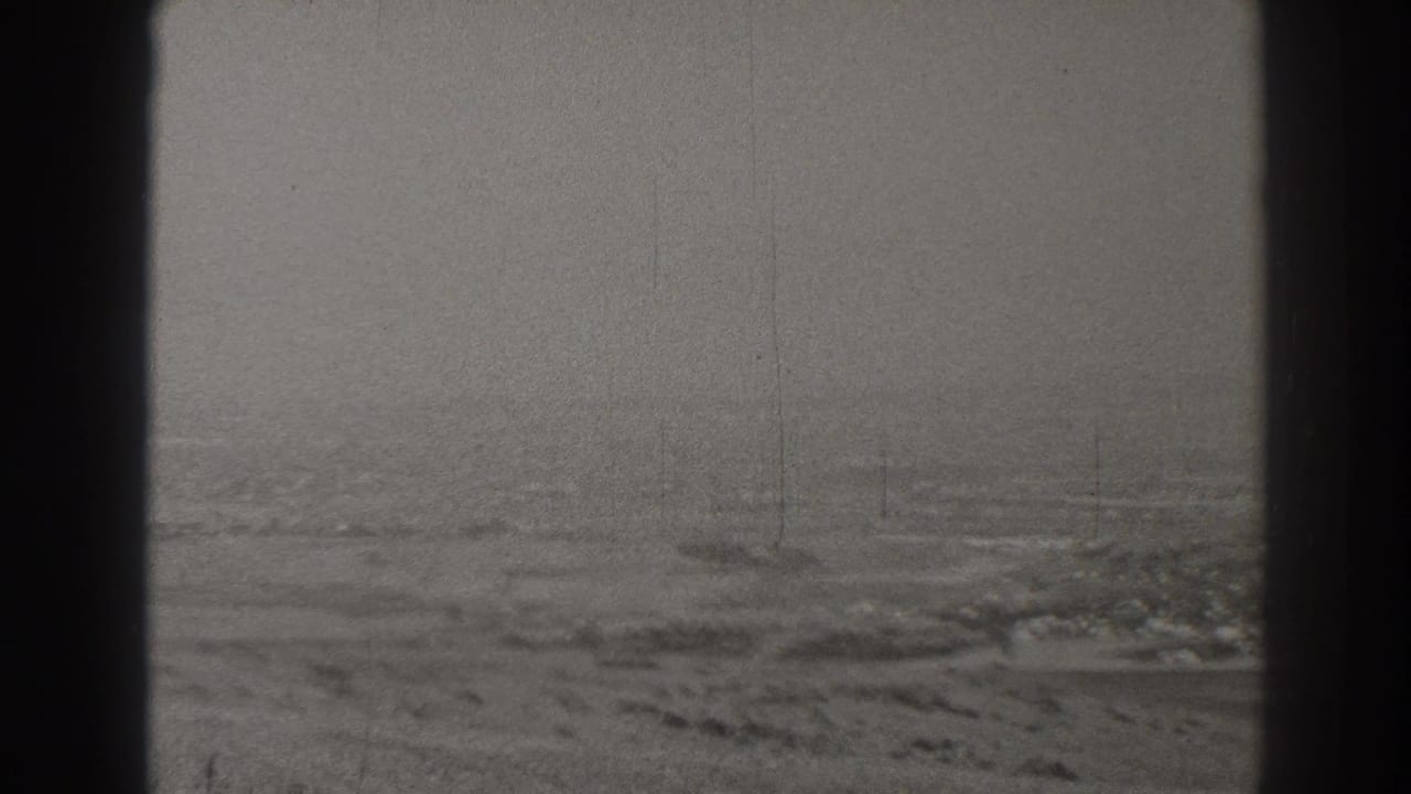Foggy aerial landscape seen through dark aircraft window framing.