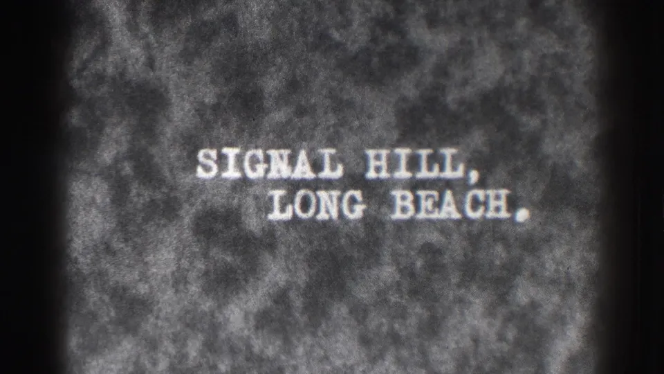 Centered title card from the 1937 home movie, with white text reading Signal Hill, Long Beach over a textured film background.