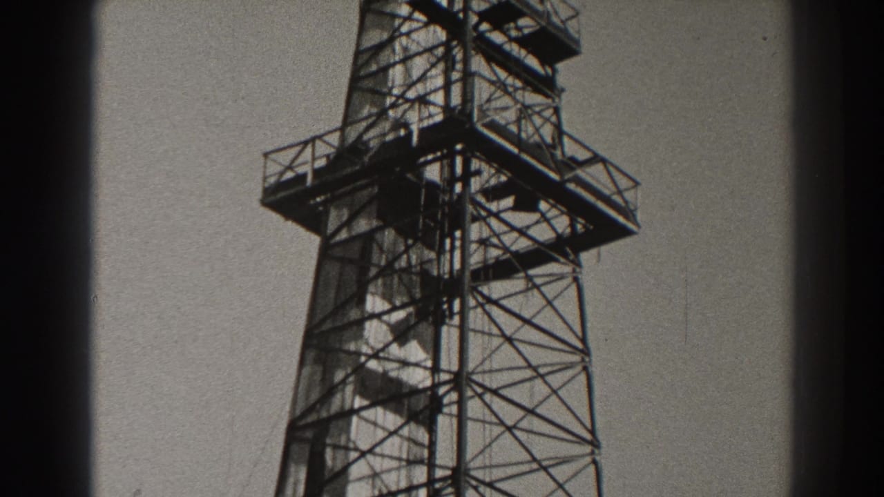 1937 Long Beach home-movie frame showing the upper portion of a tall metal lattice tower with railings and platforms.