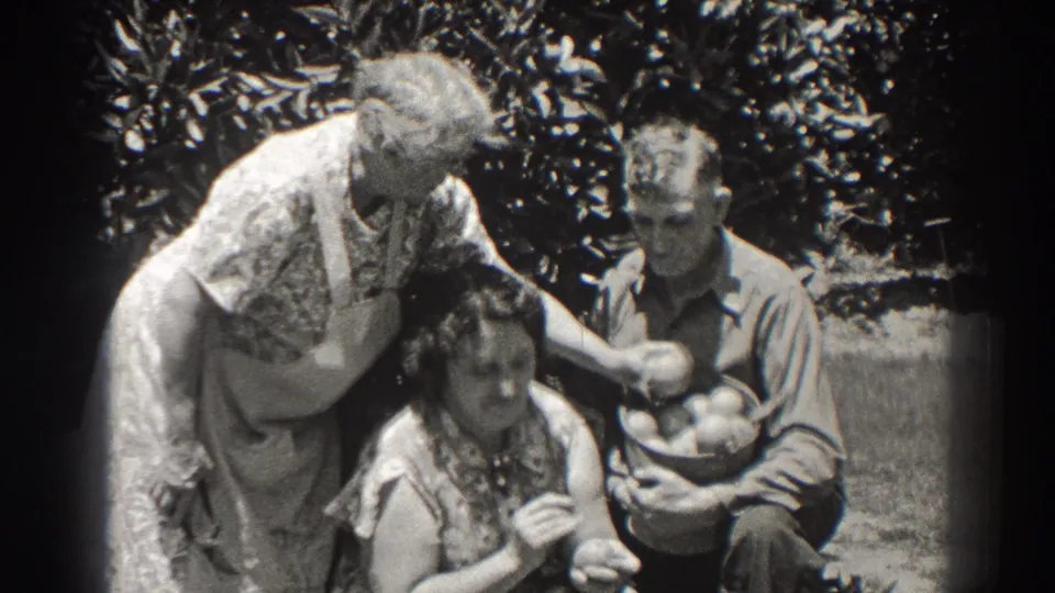 In the 1937 Long Beach garden scene, a woman reaches across the frame with fruit as the seated pair look toward the camera.