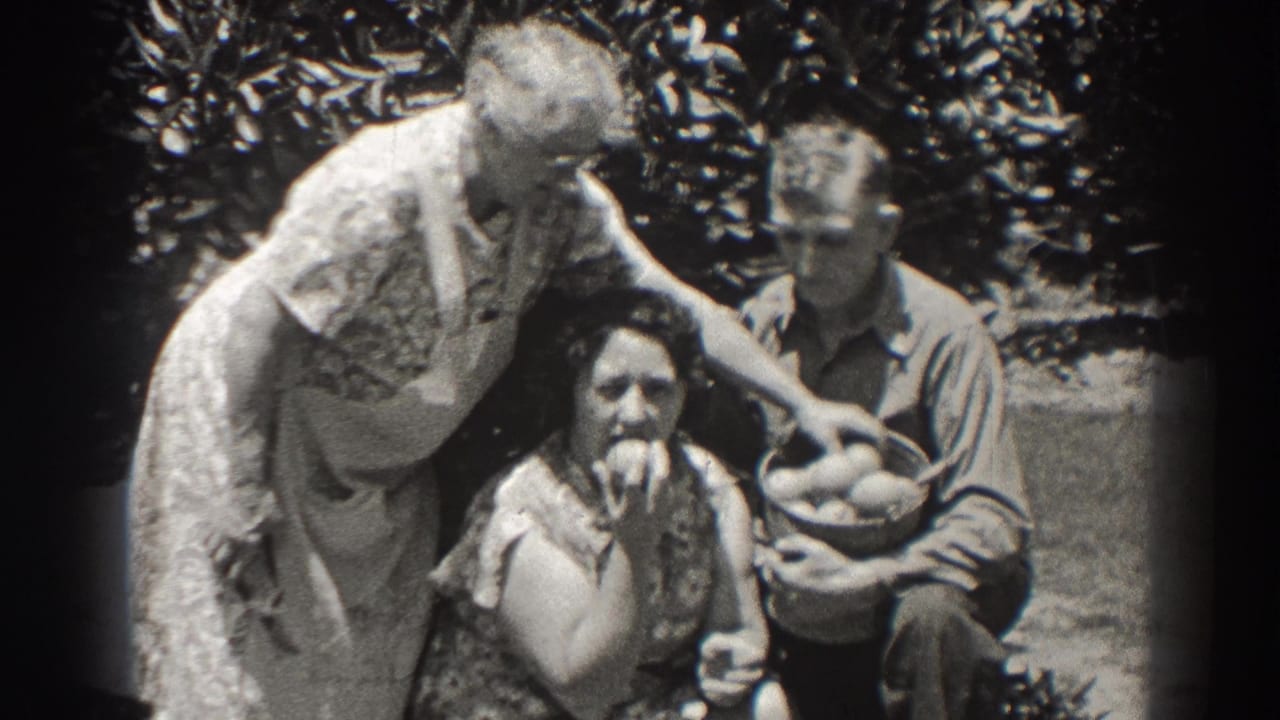 Three adults outdoors with apples and a fruit basket under leafy trees.
