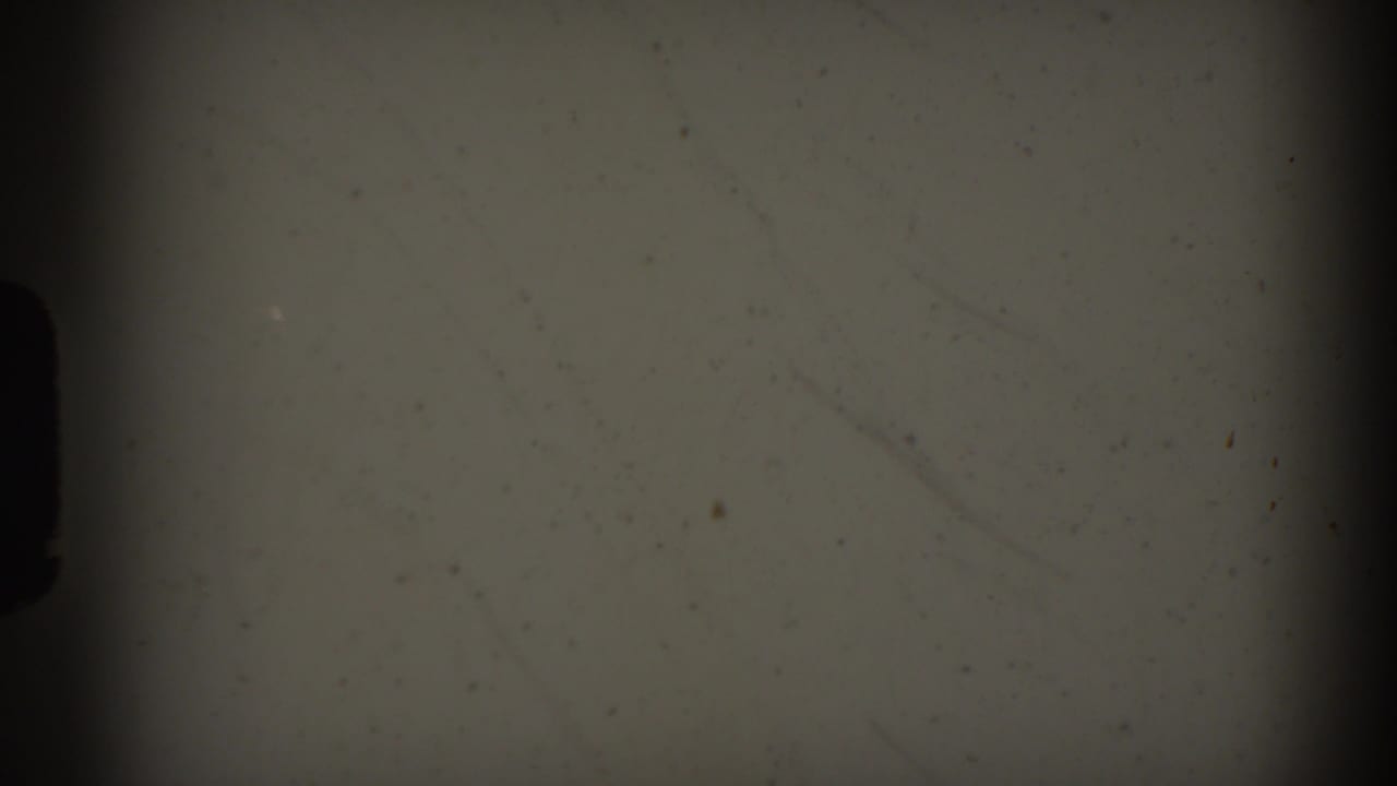 Mostly blank 8mm frame area with dark gate edge and faint film dust.
