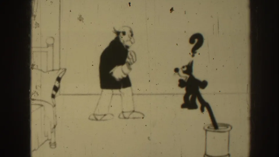 In the 1937 8mm cartoon scene, an older male figure stands beside a black cat marked by a question mark in a sparse room drawing.
