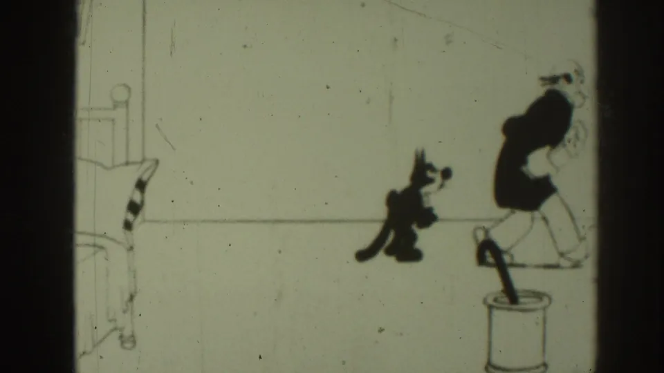 The 1937 8mm frame shows the black cat following the older cartoon man as he moves across the sparse drawn room.