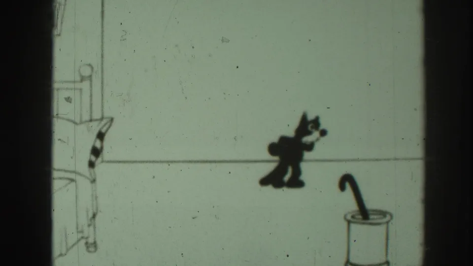 In this Sacramento 1937 8mm animation frame, a black cartoon cat moves toward an umbrella stand beside sparse line-drawn furniture.