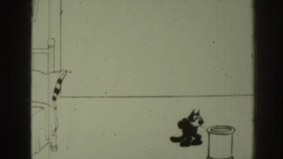 The black cartoon cat is low to the floor near the umbrella stand, suggesting a jump or landing within the slapstick sequence.