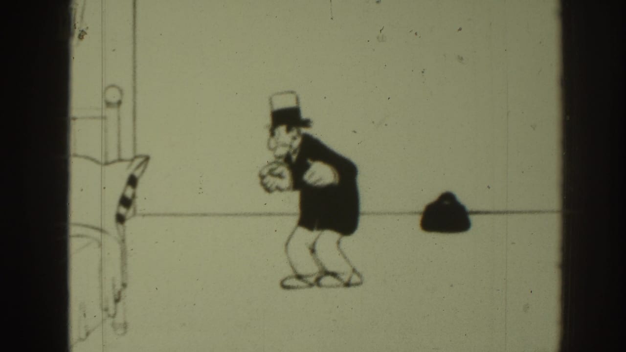 1937 8mm frame of a black-and-white cartoon figure in a top hat and coat beside a small bag against a sparse drawn backdrop.