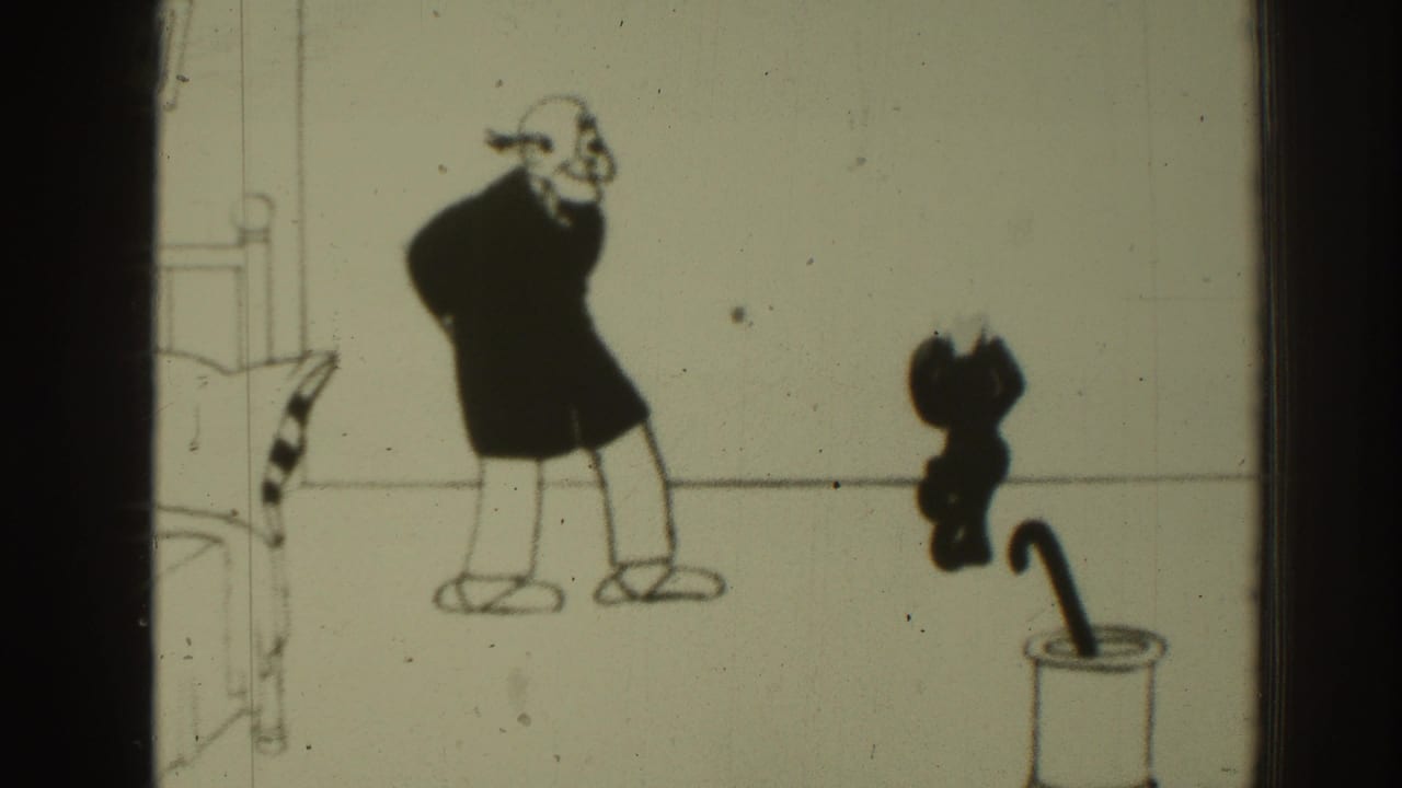 1937 8mm frame from a Felix the Cat animated scene, with Felix emerging near a container while a stooped man reacts in a simple room.