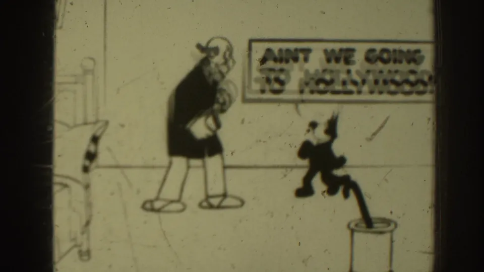 1937 Sacramento 8mm frame with the same cartoon cat and balding man, the Hollywood speech bubble partially cut off by the frame edge.