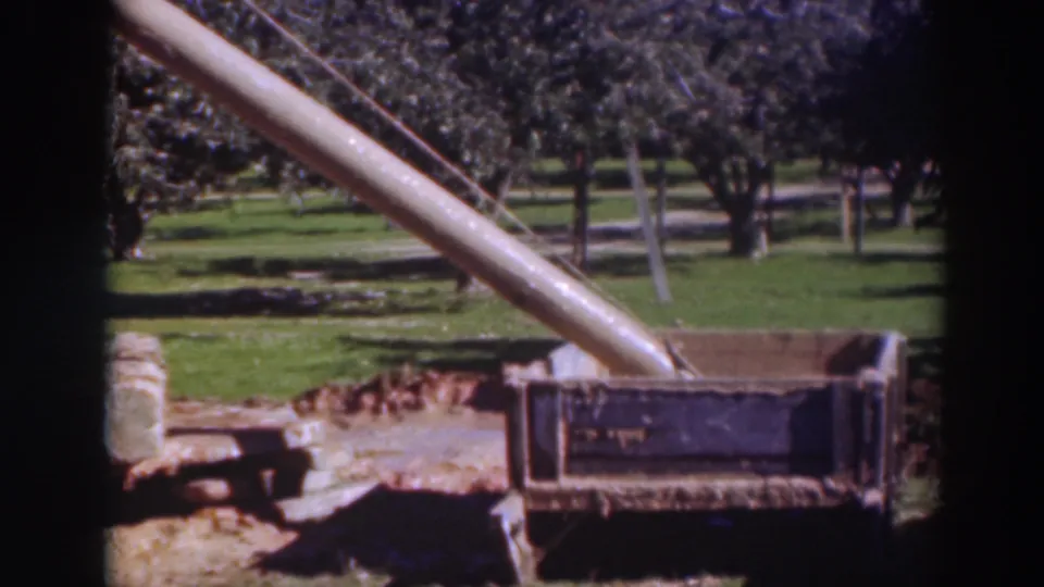Fixed 8mm view of a concrete chute and sidewalk form in Sacramento, with landscaped grass and trees in the background.