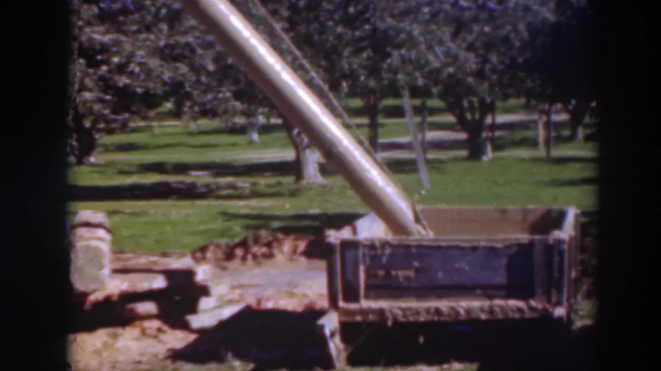 The Sacramento orchard view continues, showing the chute, crate, grass, and tree rows in soft 8mm color.