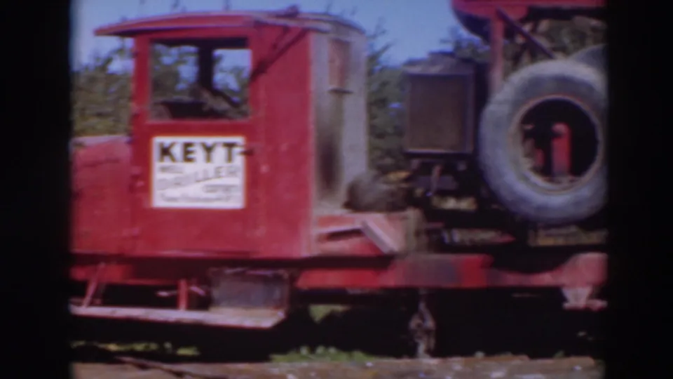 A red Keyt well-drilling rig appears in the orchard footage, showing side lettering, a spare tire, and machinery components.