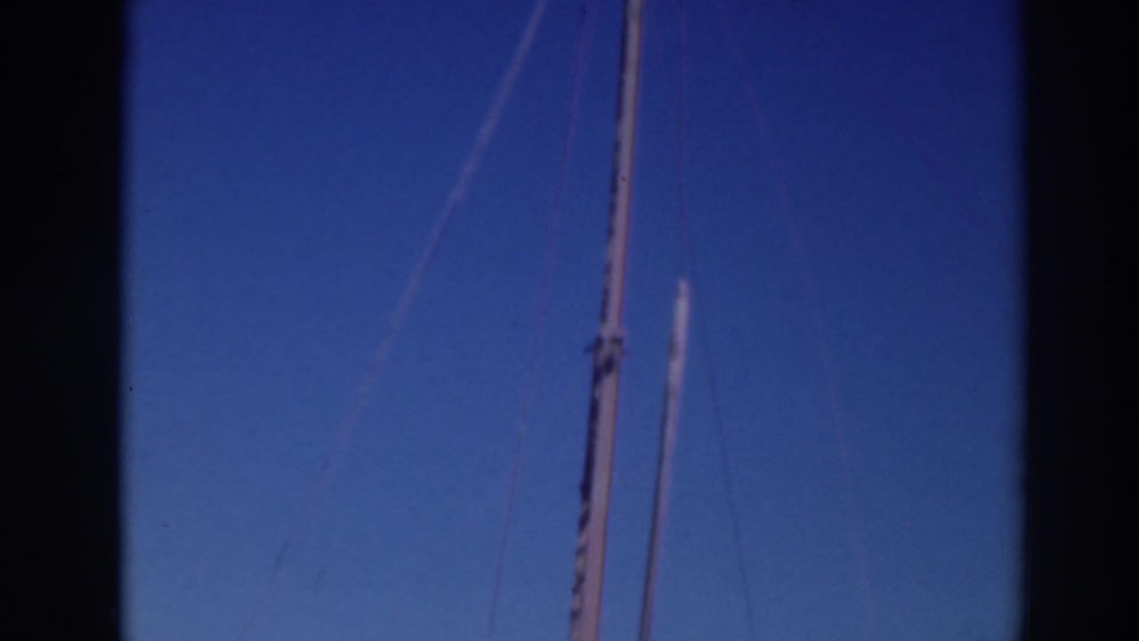 1937 Sacramento home-movie frame showing a tall boat mast or pole with rigging lines against a blue sky.