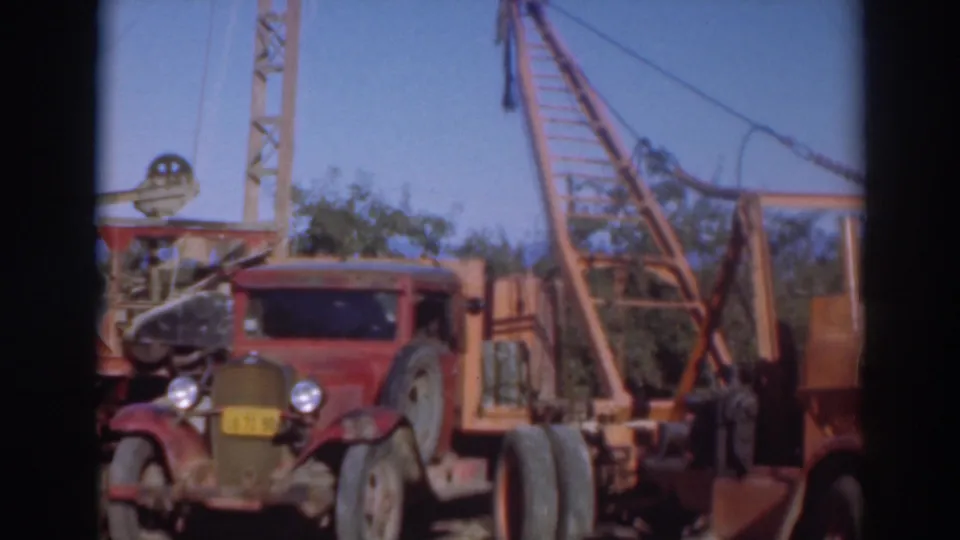 1937 Sacramento 8mm frame showing a red older truck parked near a large crane in a sunlit outdoor yard.