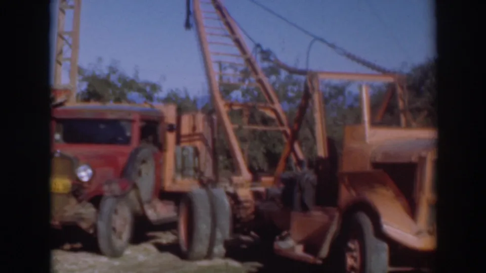 The pan moves across a red truck and orange crane machinery in the Sacramento industrial yard.