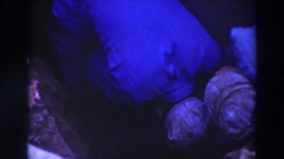 Final blue-tinted 1937 Sacramento frame with two workers crouched in a muddy trench, seen from above in dim exposure.