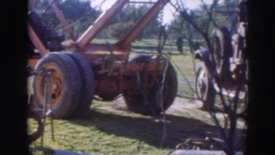 1937 Sacramento frame showing the tow truck's dual tires, rigging and adjacent work-truck body in an orchard setting.