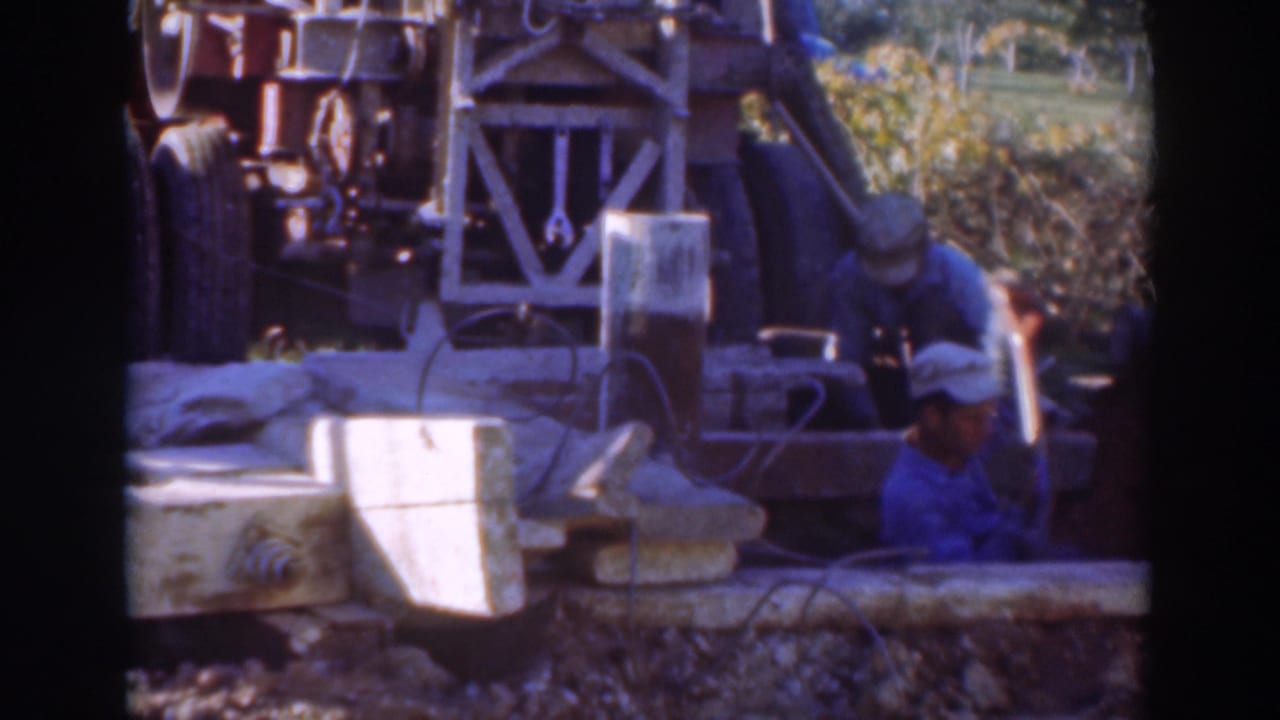 1937 Sacramento footage showing workers in caps near a drilling rig, trench edge, cables, and sunlit construction debris.