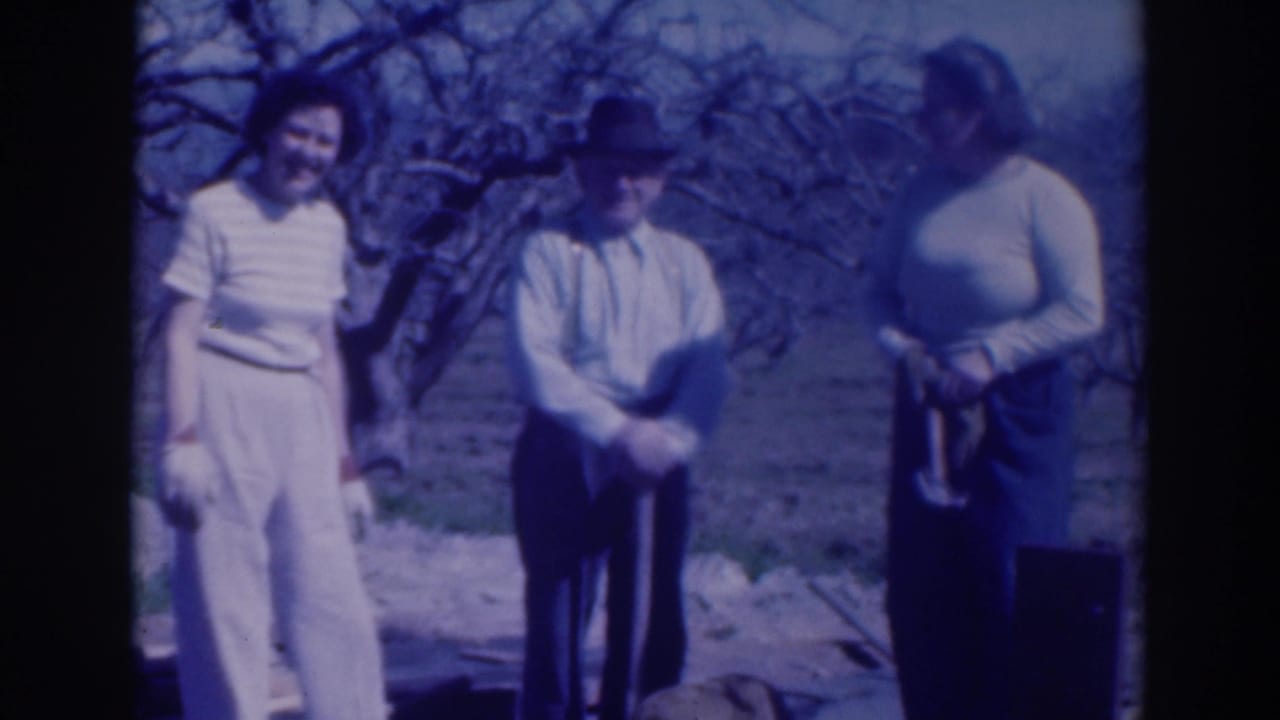 Two women and a man in 1937 Sacramento stand together in a garden area, with one person holding a long-handled tool.