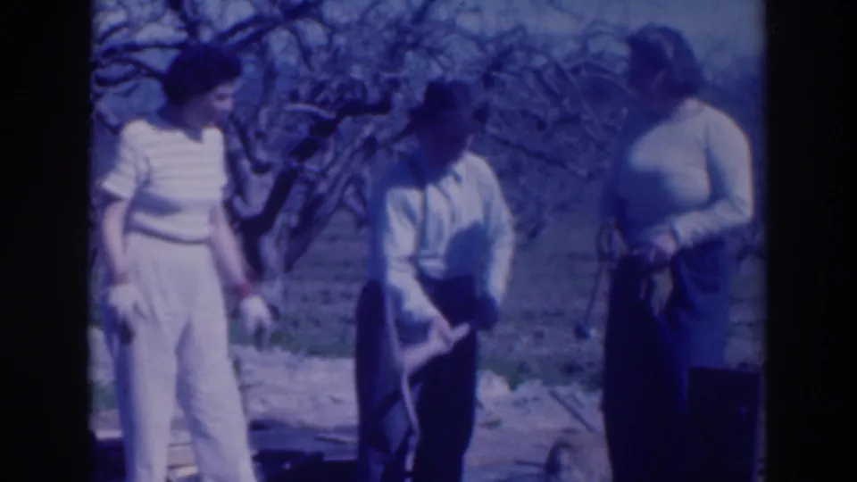 A 1937 Sacramento garden scene shows three adults conversing while the man leans on or presses a digging tool into the ground.