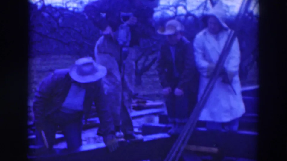 Sacramento 1937 home-movie still of adult workers grouped at an outdoor timber frame, with bare trees behind them.