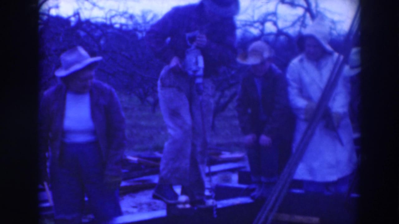 Several adults in 1937 Sacramento footage stand on or beside a wooden platform while one person appears to handle a tool near boards.