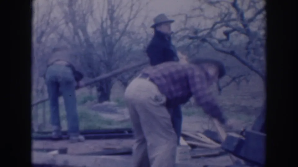 In the final frame, two men bend near wooden boards while a third stands in the leafless rural Sacramento setting.