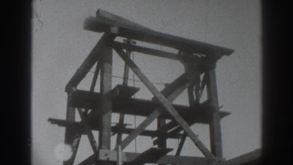 Close view of the upper timber framework in a 1937 Sacramento rural construction scene, with braces silhouetted against the sky.