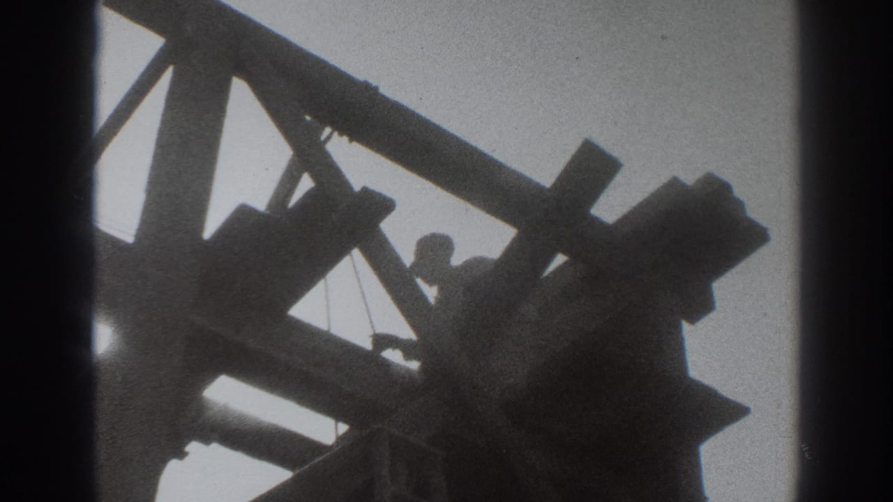 Silhouetted worker among wooden beams against a bright sky.