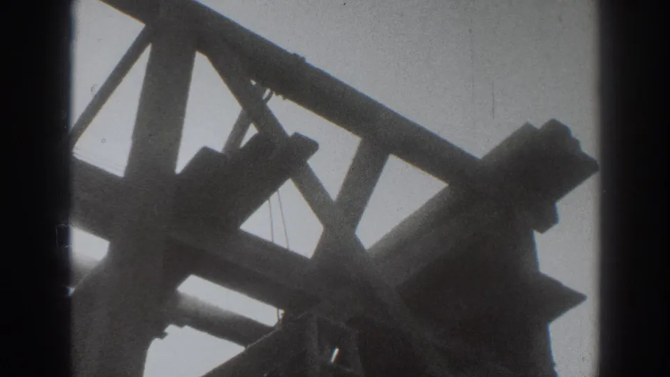 Late-frame 1937 Sacramento construction view showing angled house framing and braces in silhouette.