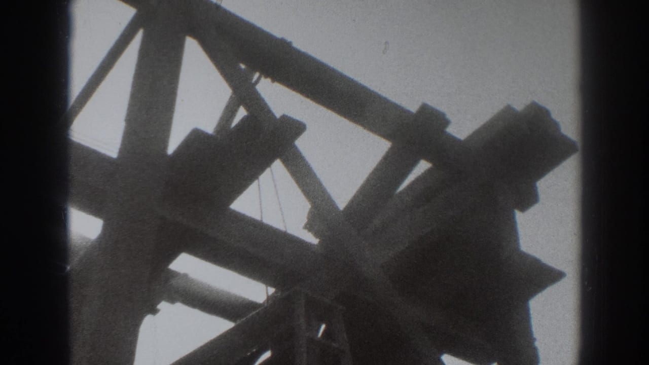 Low-angle view of dark timber beams and bracing against a pale sky.
