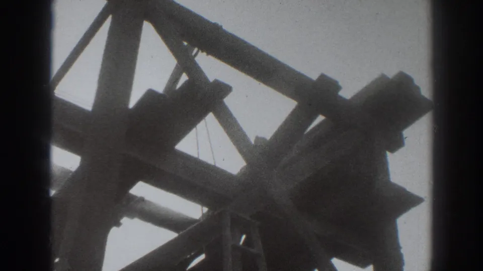 Low-angle 1937 Sacramento frame of a wooden construction structure, with cross-bracing and beam ends silhouetted against the sky.