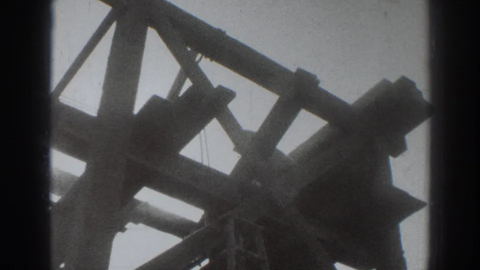 Archival 8mm frame from Sacramento showing a dense arrangement of timber beams and supports viewed from beneath the structure.