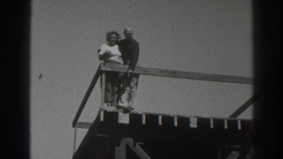 A woman in light clothing and a man in darker clothing stand together on the platform in this 1937 Sacramento 8mm frame.