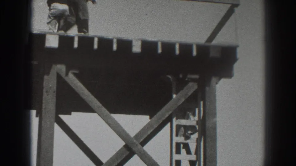 A final 1937 Sacramento frame shows the timber scaffold from below the platform, with diagonal braces and a small partly obscured worker on the ladder.