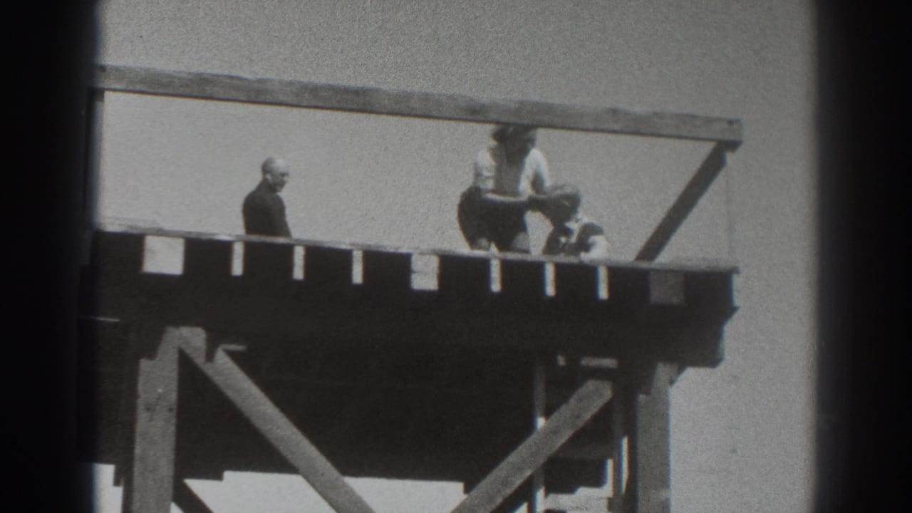 Near the end of the 1937 Sacramento clip, a crouching figure appears to handle a hat while two others remain on the platform.