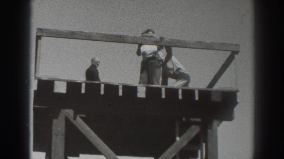 1937 Sacramento frame with people gathered on a timber observation platform, one figure standing apart and others near the rail.