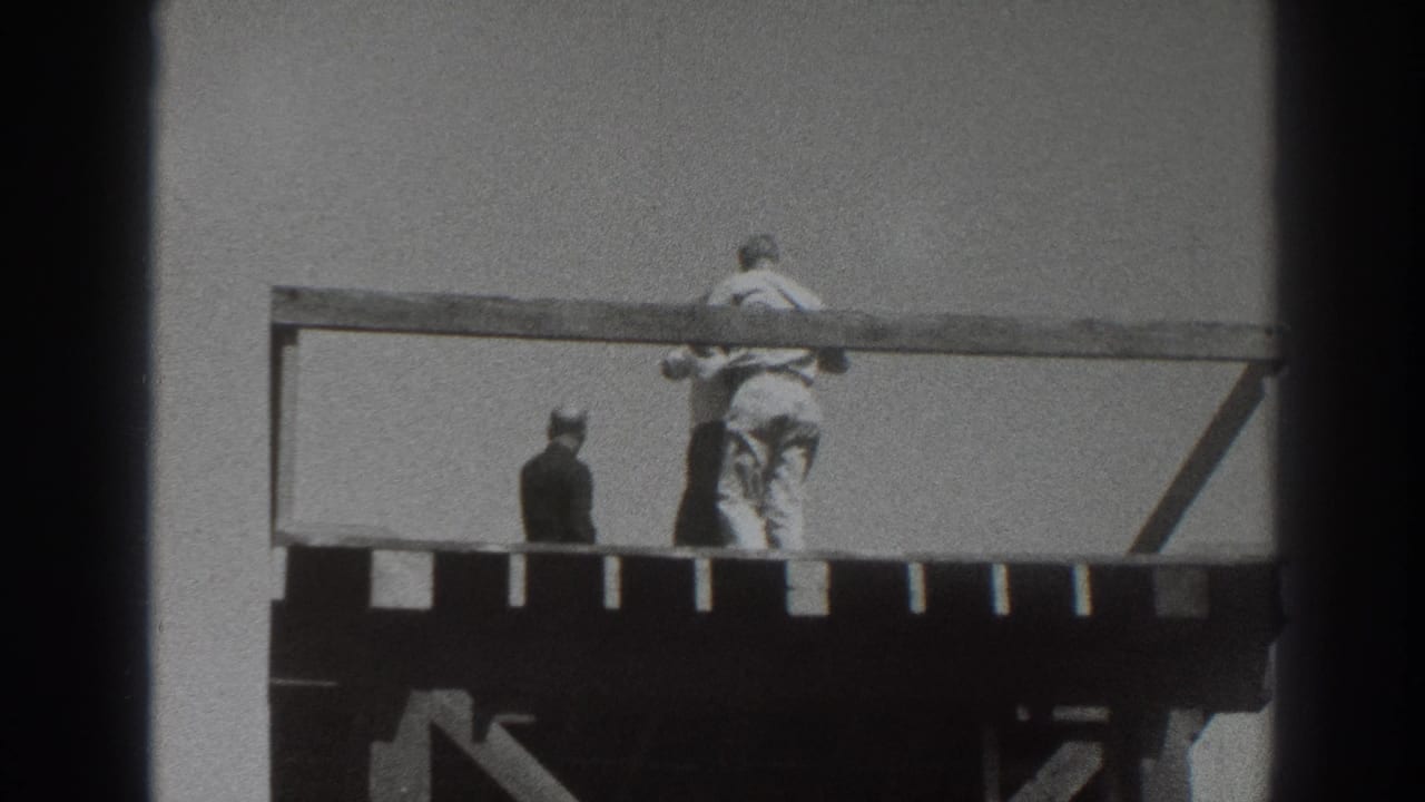 1937 Sacramento home-movie frame showing figures on a raised wooden tower deck, with one person at the rail and another turned away.