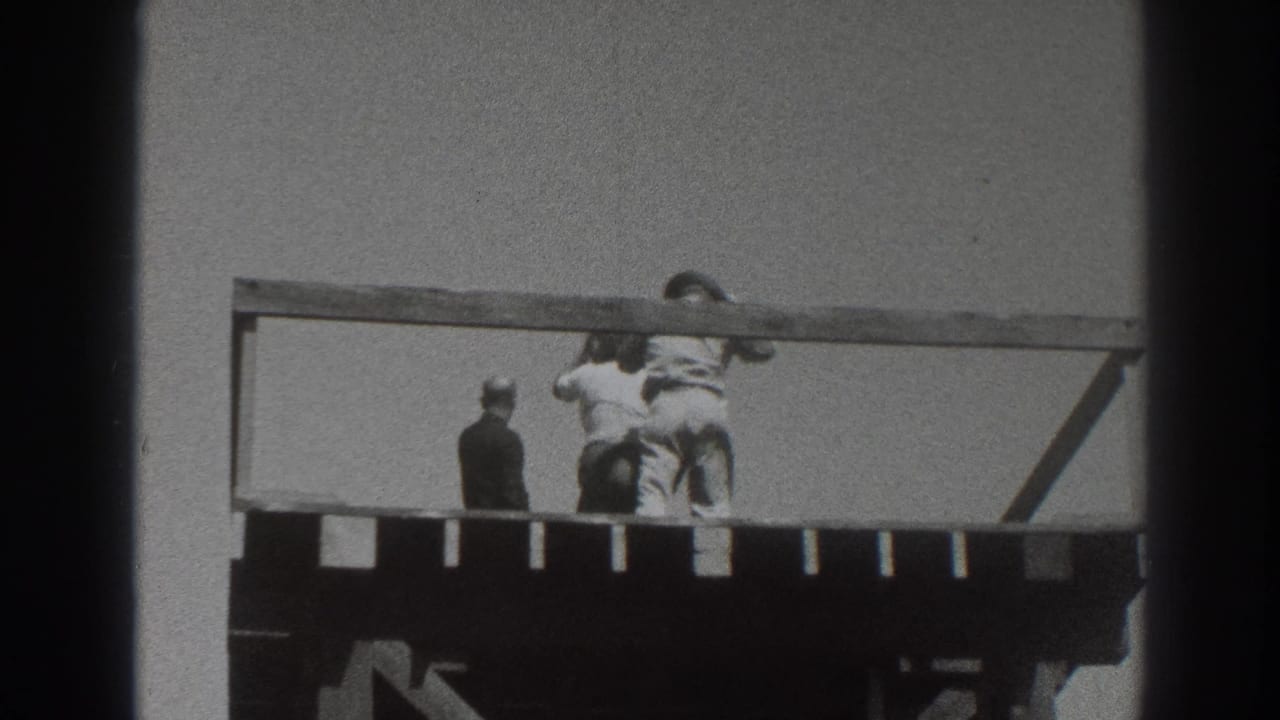 Three adults on a raised wooden deck behind a simple railing.