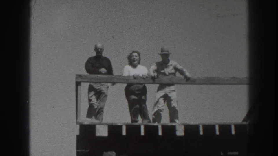 Three adults on a wooden tower platform in Sacramento, California, 1937, with bright sky and distant horizon behind them.