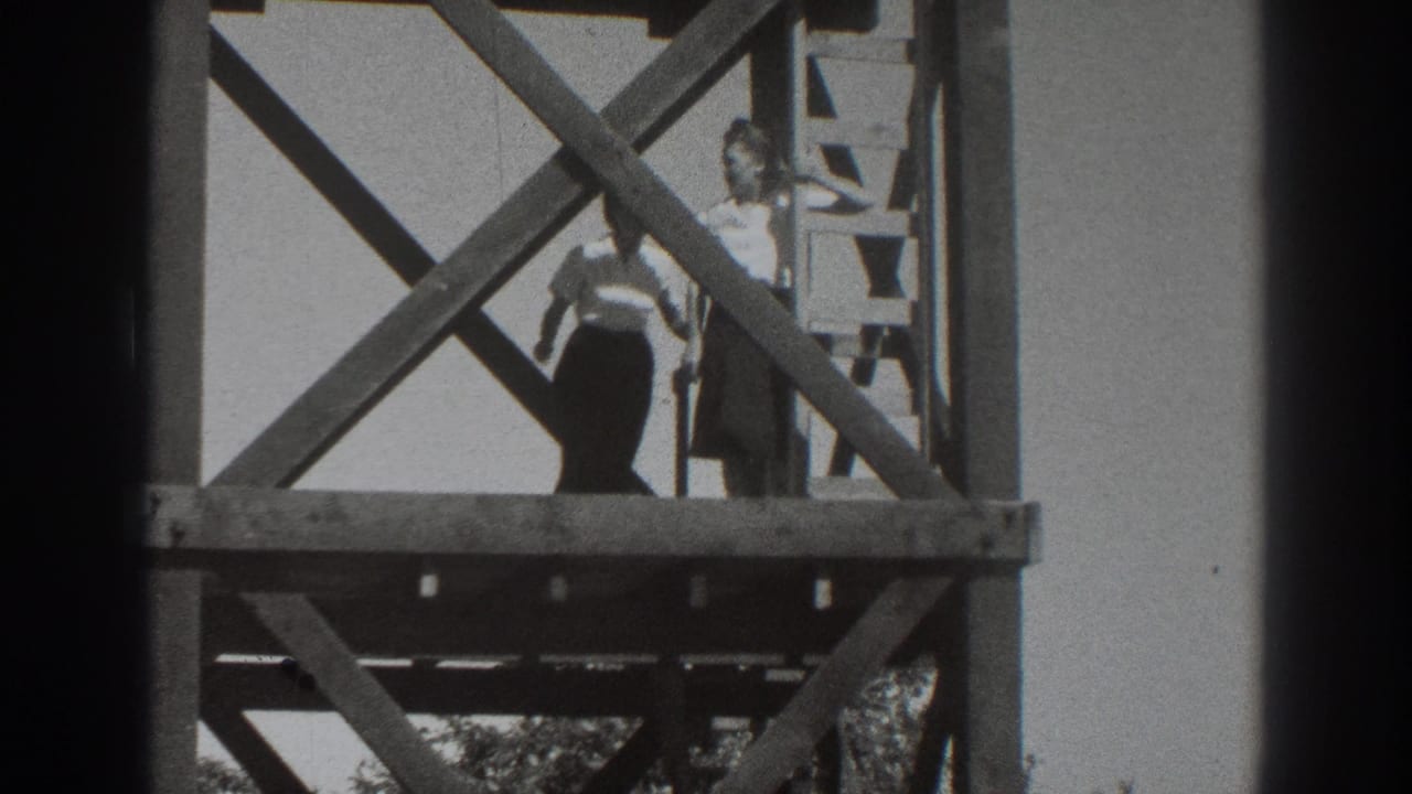 A woman in a light top stands on a lower wooden platform beside a ladder and diagonal braces in Sacramento, 1937.