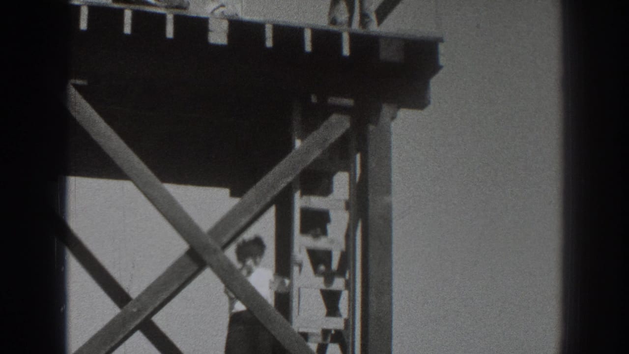 Man climbing a ladder beneath a raised wooden platform with another worker partly visible above.