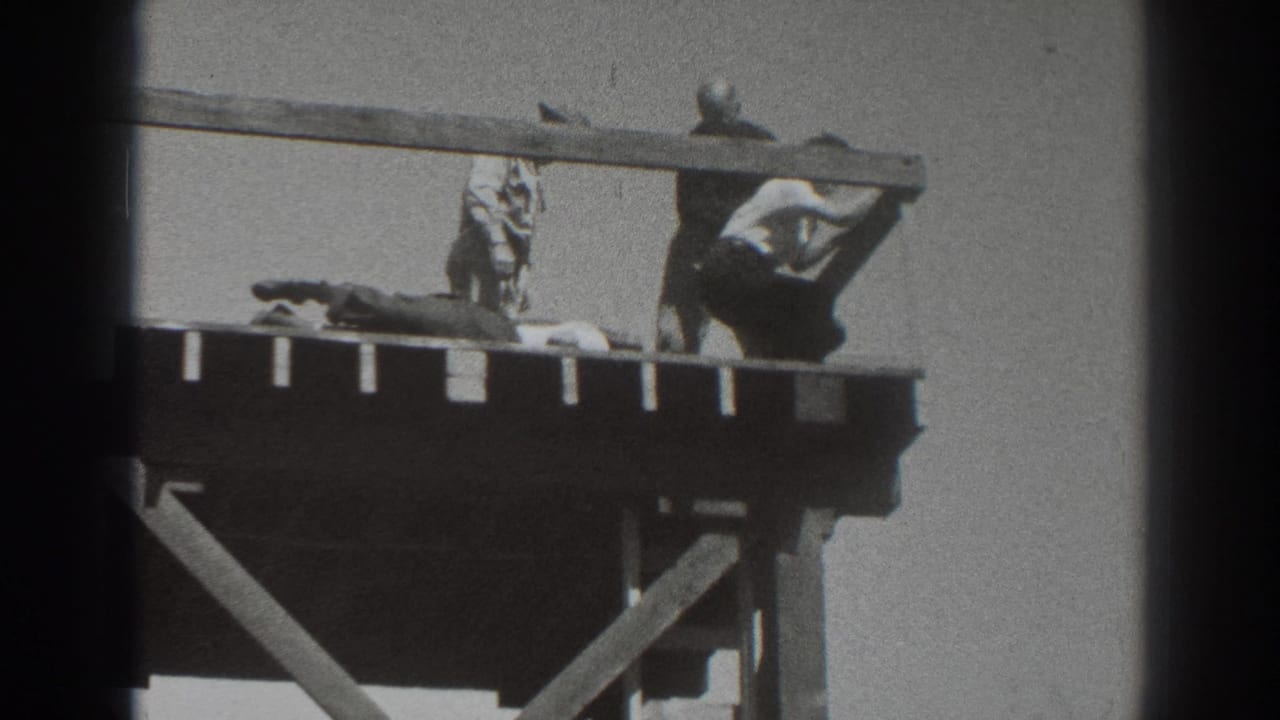 Adults on a raised wooden tower platform with one person lying down.