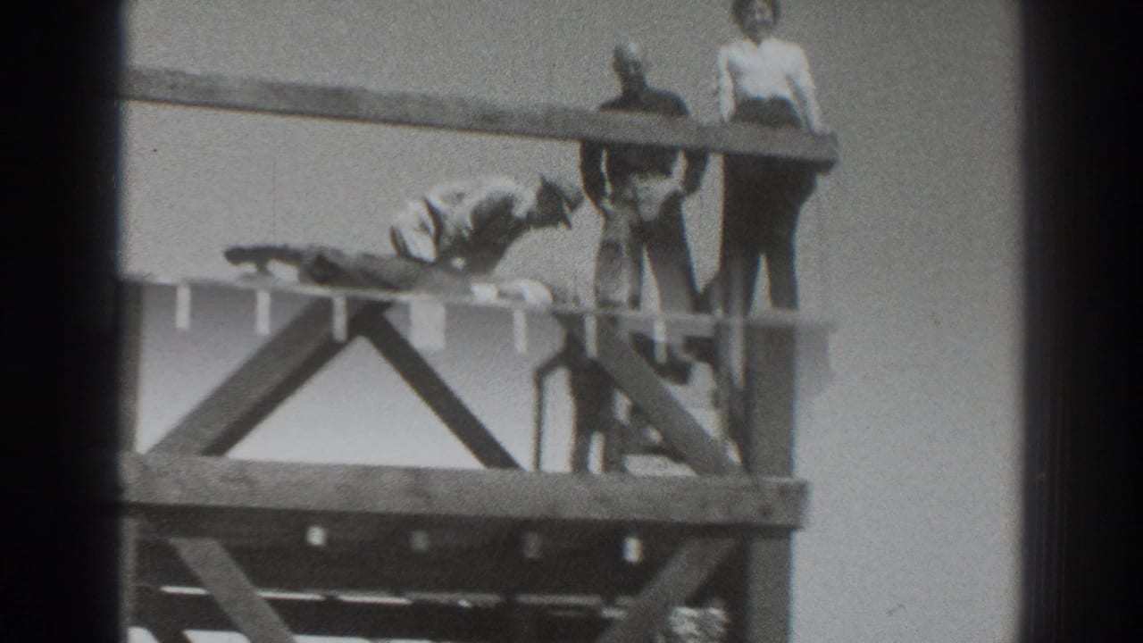 1937 Sacramento frame with adults on the wooden tower and a figure lower on the structure near the ladder.