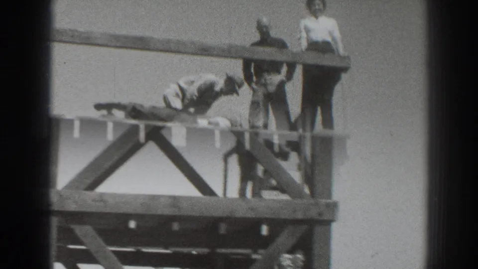 1937 Sacramento frame with adults on the wooden tower and a figure lower on the structure near the ladder.