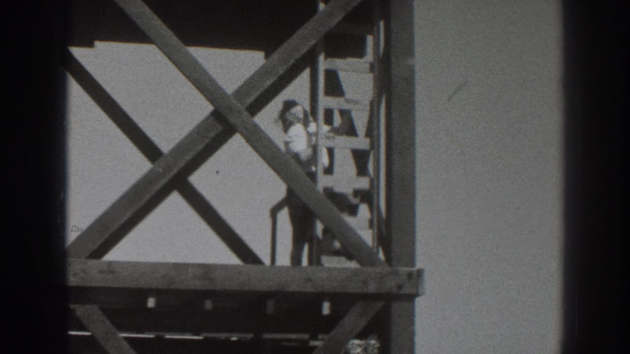 1937 Sacramento home-movie frame showing the tower supports and a person climbing down or standing on the ladder.