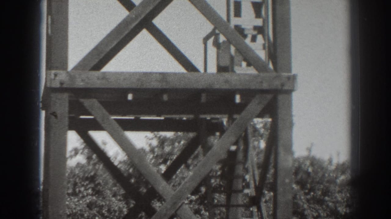 1937 Sacramento frame showing the upper platform of a wooden tower with a small person silhouetted near the railing.