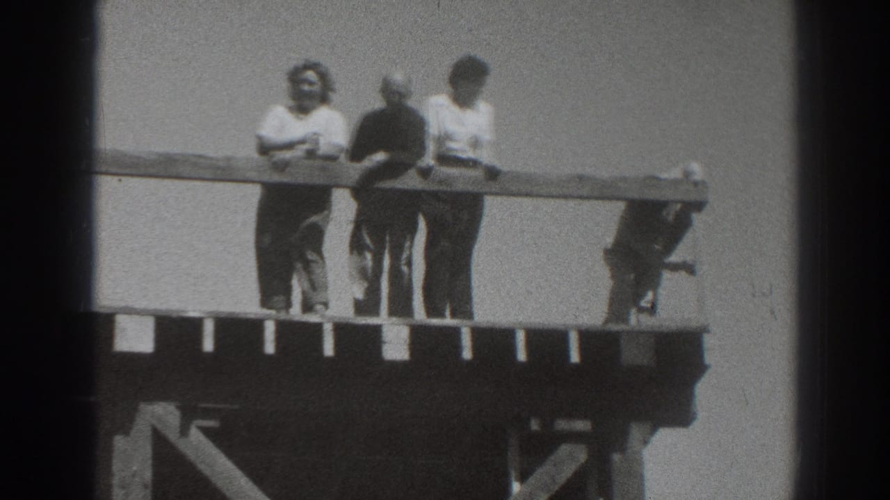 1937 Sacramento home-movie frame showing adults gathered at a railing on a raised wooden platform against open sky.