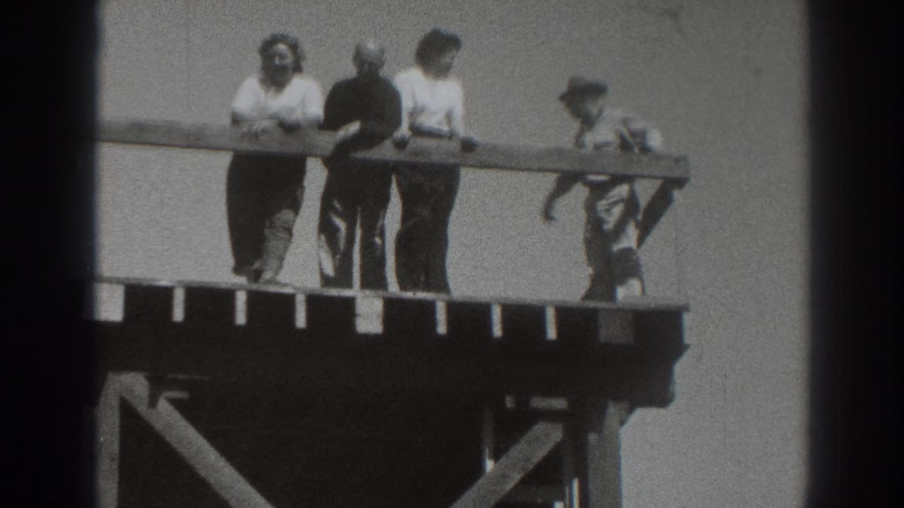1937 Sacramento home-movie frame showing a group at a wooden platform railing, with a smaller figure near the right side.